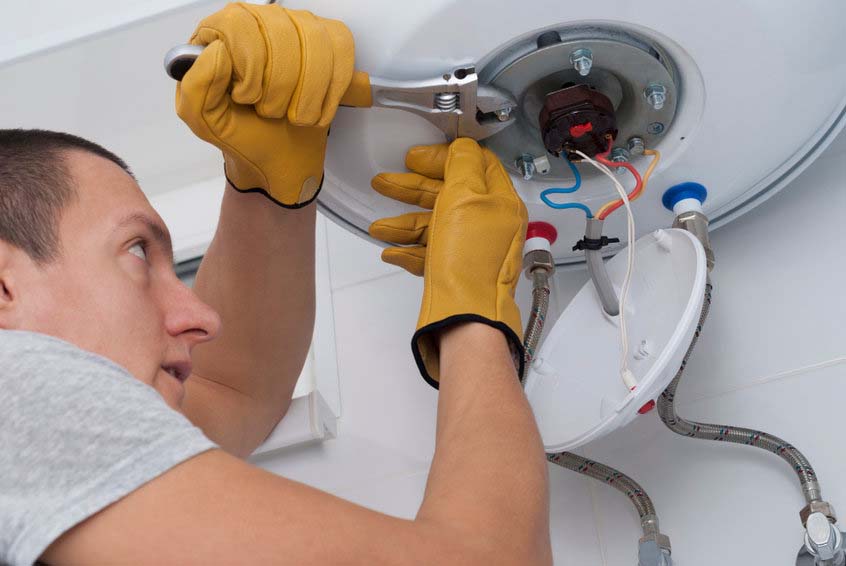 a technician fixing a water heater