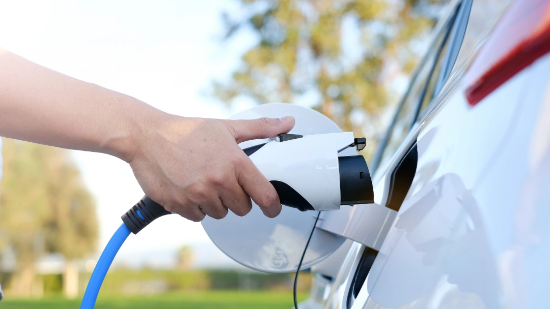 A person plugging in their EV