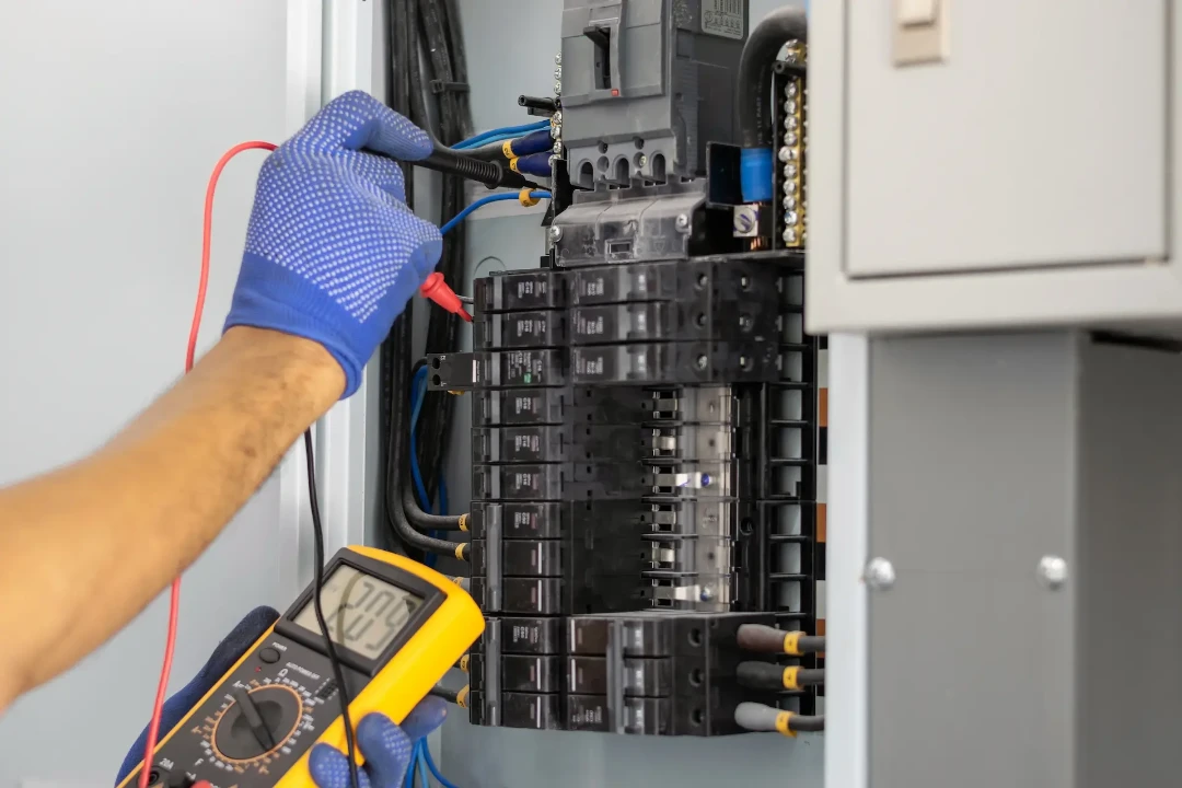 An electrician servicing a panel