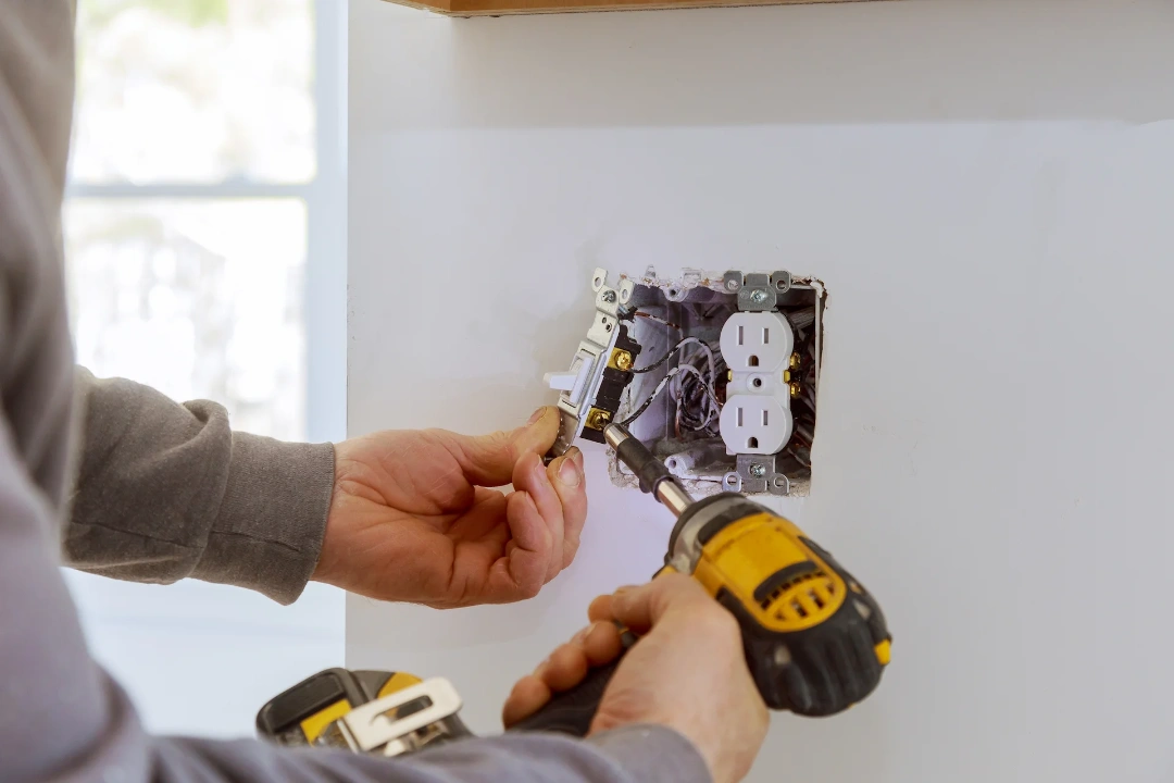 An electrician working on a light switch